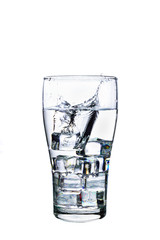 Splashed water with ice cube in glass on white background