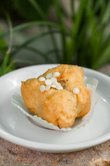 eclairs decorated with beads of white chocolate on a white plate