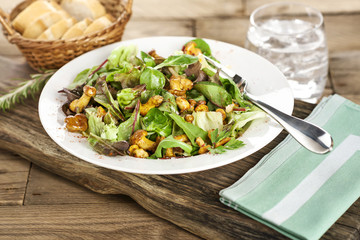 Mediterraner Salat mit Pfiferlingen auf weißem Teller servierfertig angerichtet