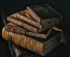 Shakespeare old books stack dark directional light. Selective focus on Shakespeare title. 