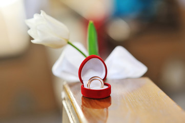 wedding rings in a heart shaped box and flower