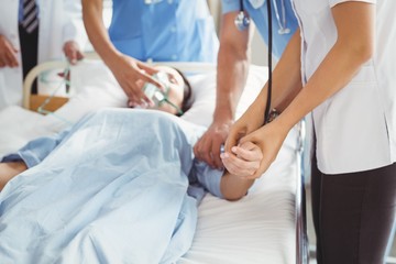 Obraz na płótnie Canvas Doctor checking female patient pulse