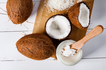 Whole and broken coconut with grated cocont flakes and coconut oil or butter. - obrazy, fototapety, plakaty