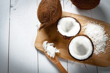 Whole and broken coconut with grated cocont flakes and coconut oil or butter.