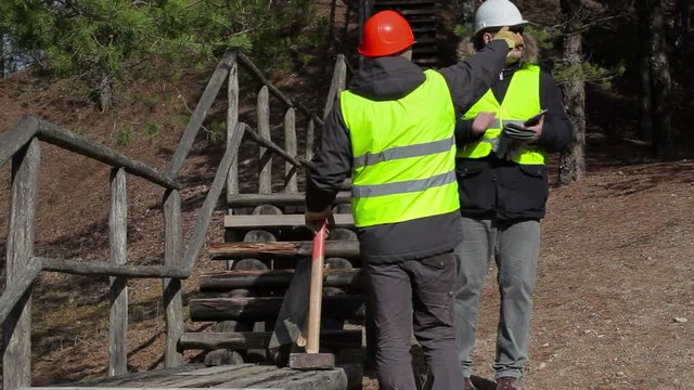 Workers talking near to the broken wooden track 
