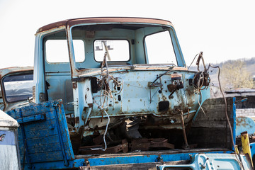 part of the dismantled rusty blue car in the dumps
