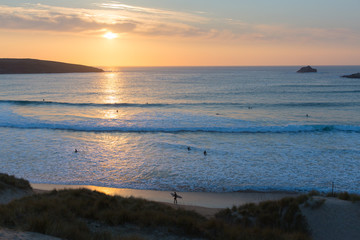 Obraz na płótnie Canvas Sunset Cornwall surfers surfing Crantock bay near Newquay uk