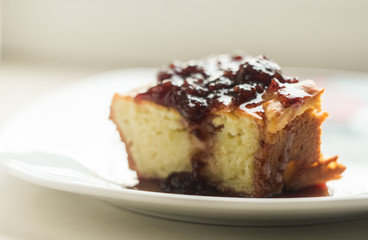 piece of homemade pie on a plate with berry jam