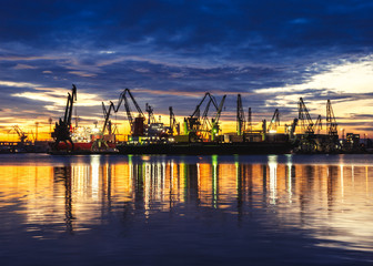 Evening panorama of the cargo port. Loading and unloading of ships
