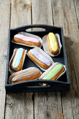 Eclairs with glaze on a grey wooden table