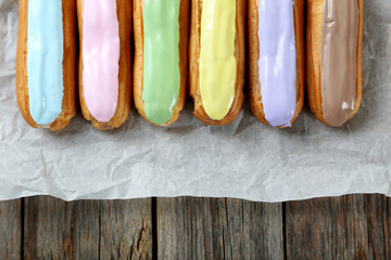 Eclairs with glaze on a grey wooden table
