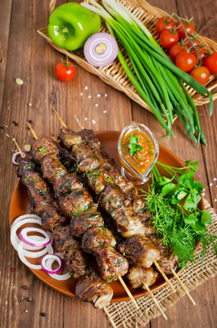 Grilled beef liver kebabs on a dark wooden background