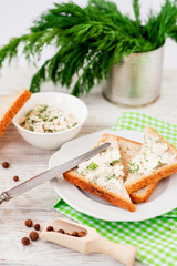 
breakfast or lunch , light sandwiches ,  rye toast with cream cheese , dill and spices on a wooden background
