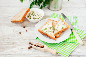 
breakfast or lunch , light sandwiches ,  rye toast with cream cheese , dill and spices on a wooden background
