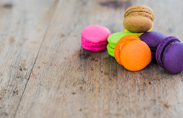 french sweet delicacy, colourful macaroons variety with wood Background