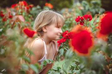 Obraz na płótnie Canvas Child with rose flower in spring garden