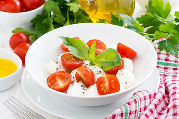 traditional salad with mozzarella and cherry tomatoes in a bowl