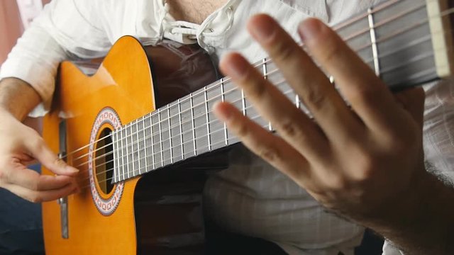 Musician playing a classical guitar in slow motion