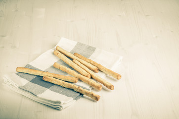 rustic breadsticks on wood table, close up, background.