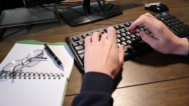 Close-up of a young male hand typing on a laptop keyboard slow motion