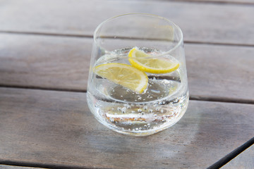 glass of sparkling water with lemon on table