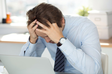 Tired businessman sitting at office