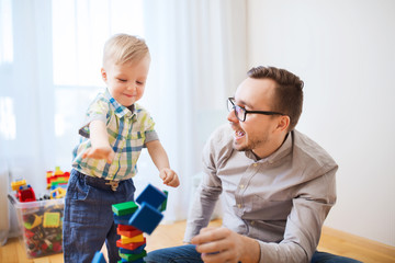 father and son playing with toy blocks at home