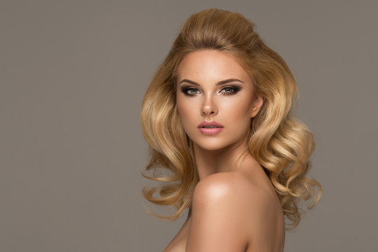 Fototapeta Sensual beautiful blonde woman posing. Girl with long curly hair.