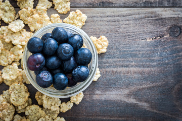 Yogurt with fresh blueberries and cereals on rustic wood
