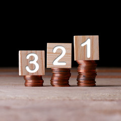 321 number with wooden block on stacked coins