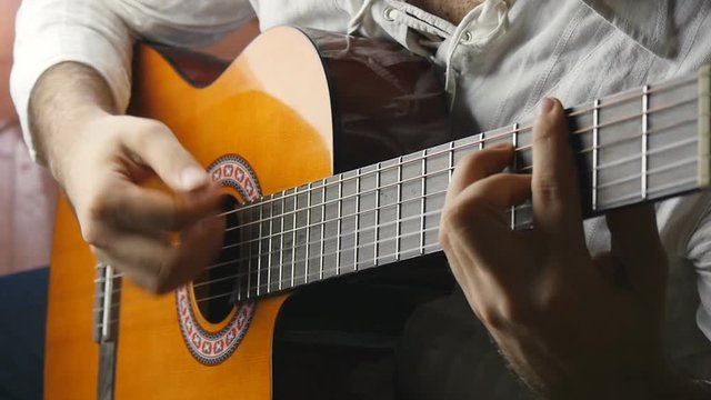 Musician playing a classical guitar in slow motion