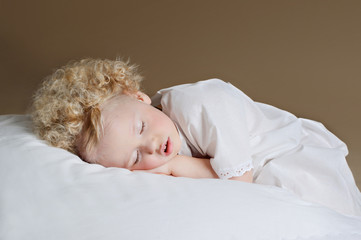 Little cute girl sleeping on a pillow