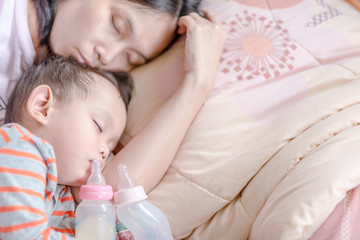 Obraz na płótnie Canvas Asian baby boy sleeping in mother arm