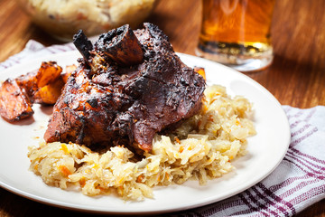 Pork knuckle with fried sauerkraut and baked potatoes