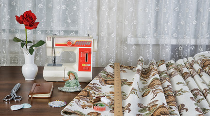 workplace оf seamstress with the sewing machine and retro fabri