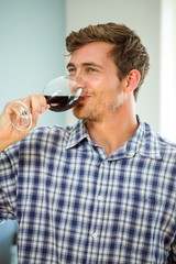 Young man having red wine