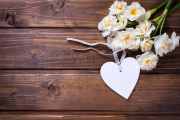 Spring yellow narcissus flowers and decorative  heart  on brown