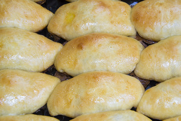 The metal baking sheet with rosy baked pies