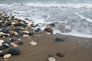 Fototapeta na wymiar pebble stones and waves