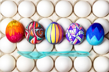 multicolored painted easter eggs on white in tray, food photography