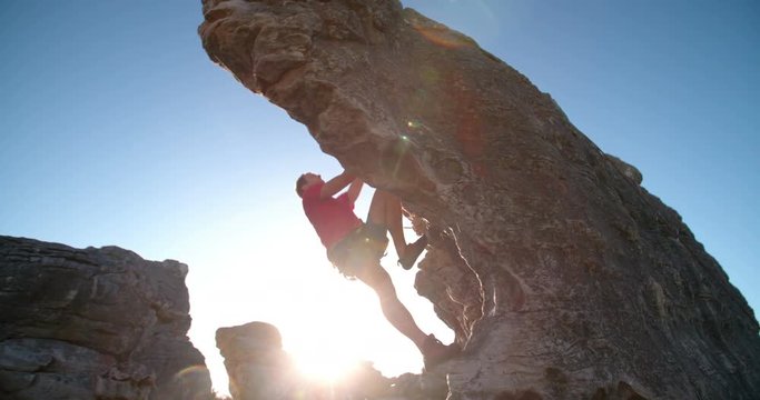 Rock climber bouldering outdoors on mountain in nature