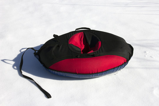 red and black material snow inner tubing (toobing) on the white