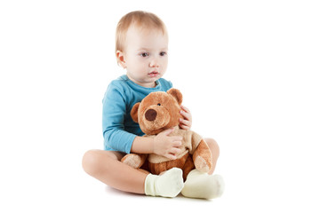 Little boy hugging a teddy bear on white background