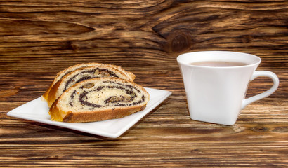 Cup of tea and roll with poppy seeds