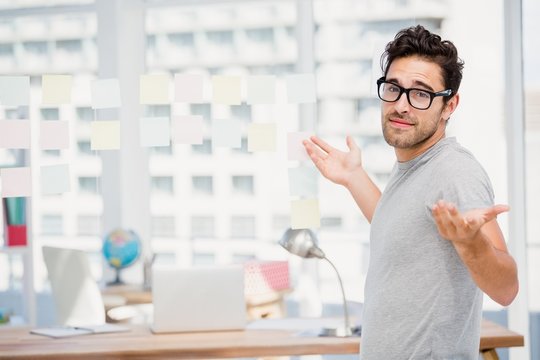 Man shrugging his shoulder in office