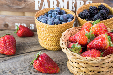 Baskets with fresh, organic, farm blueberries, strawberries and