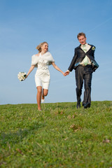 Newly wedded running along the field