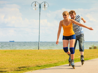 Young couple on roller skates riding outdoors