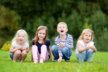 Naklejka na ściany i meble Four adorable little kids outdoors
