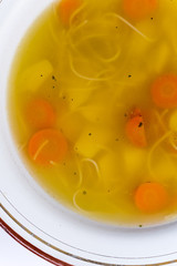Flat lay image of homemade chicken soup in the plate